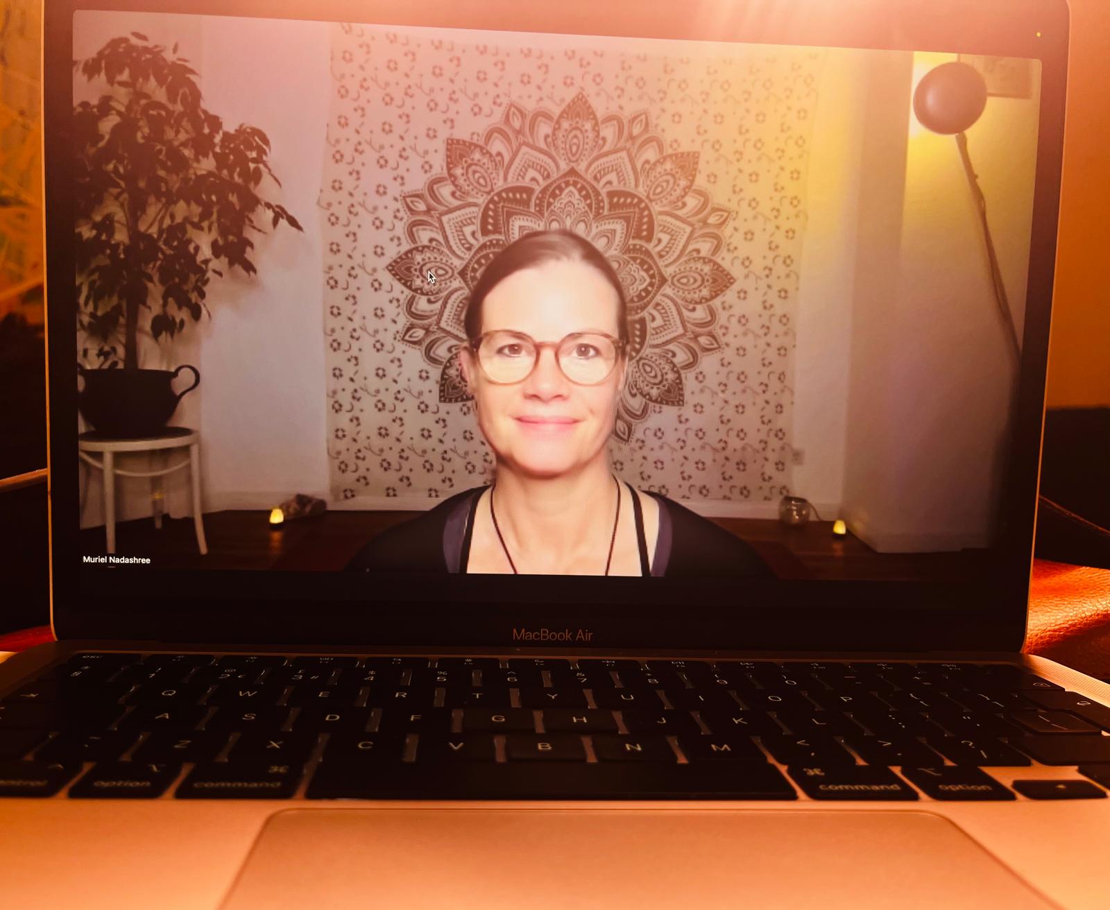Muriel on a laptop screen, ready to teach yoga online